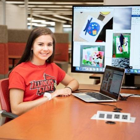 student sitting at a laptop in the library