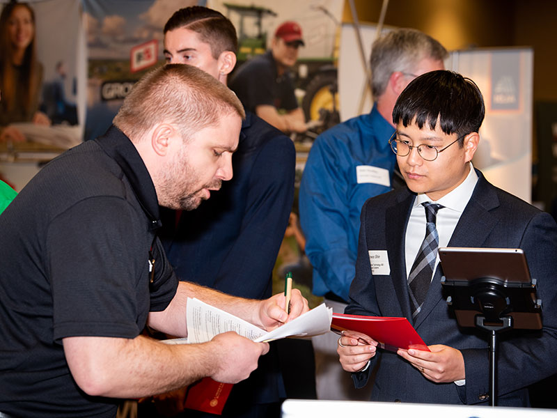 People standing together at career event looking over a piece of paper.